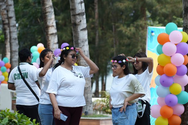 Team members with flower crowns next to a balloon pillar