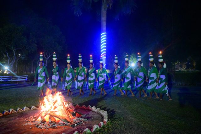 Folk dancers performing beside a bonfire