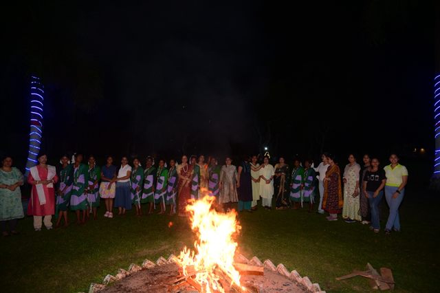 Guests gathered around a bonfire at night